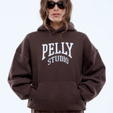 Person wearing a brown hoodie with 'PELLY STUDIO' text on a white background