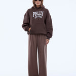 Person wearing a brown 'Pelly Studio' hoodie and pants on a white background