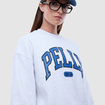 Person wearing a white sweatshirt with 'PELLY' branding and a blue cap.
