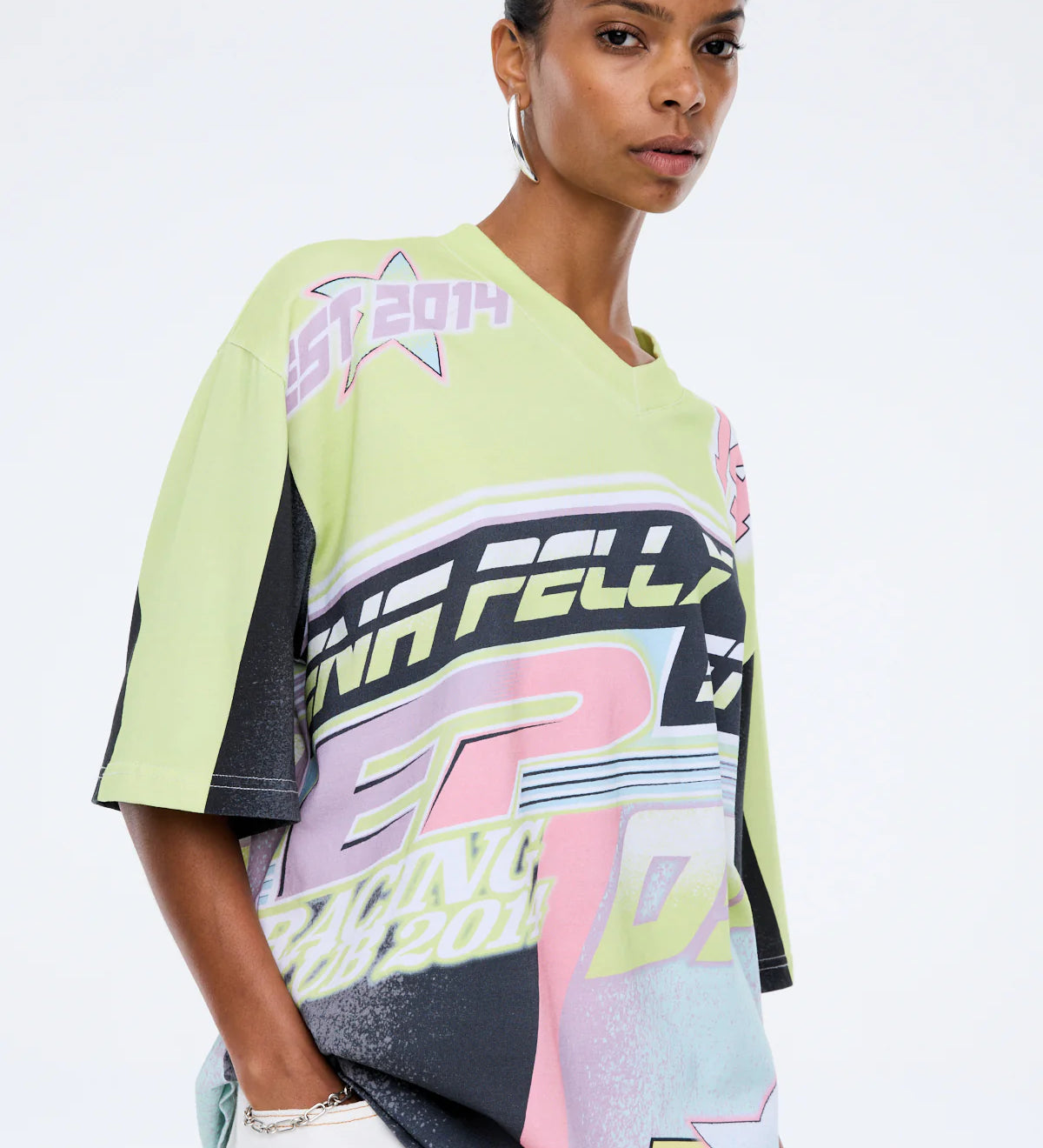 Woman wearing a colorful sports jersey with branding on a white background