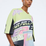 Woman wearing a colorful sports jersey with branding on a white background