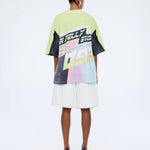 Person wearing a colorful graphic t-shirt and white shorts on a white background