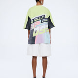 Person wearing a colorful graphic t-shirt and white shorts on a white background