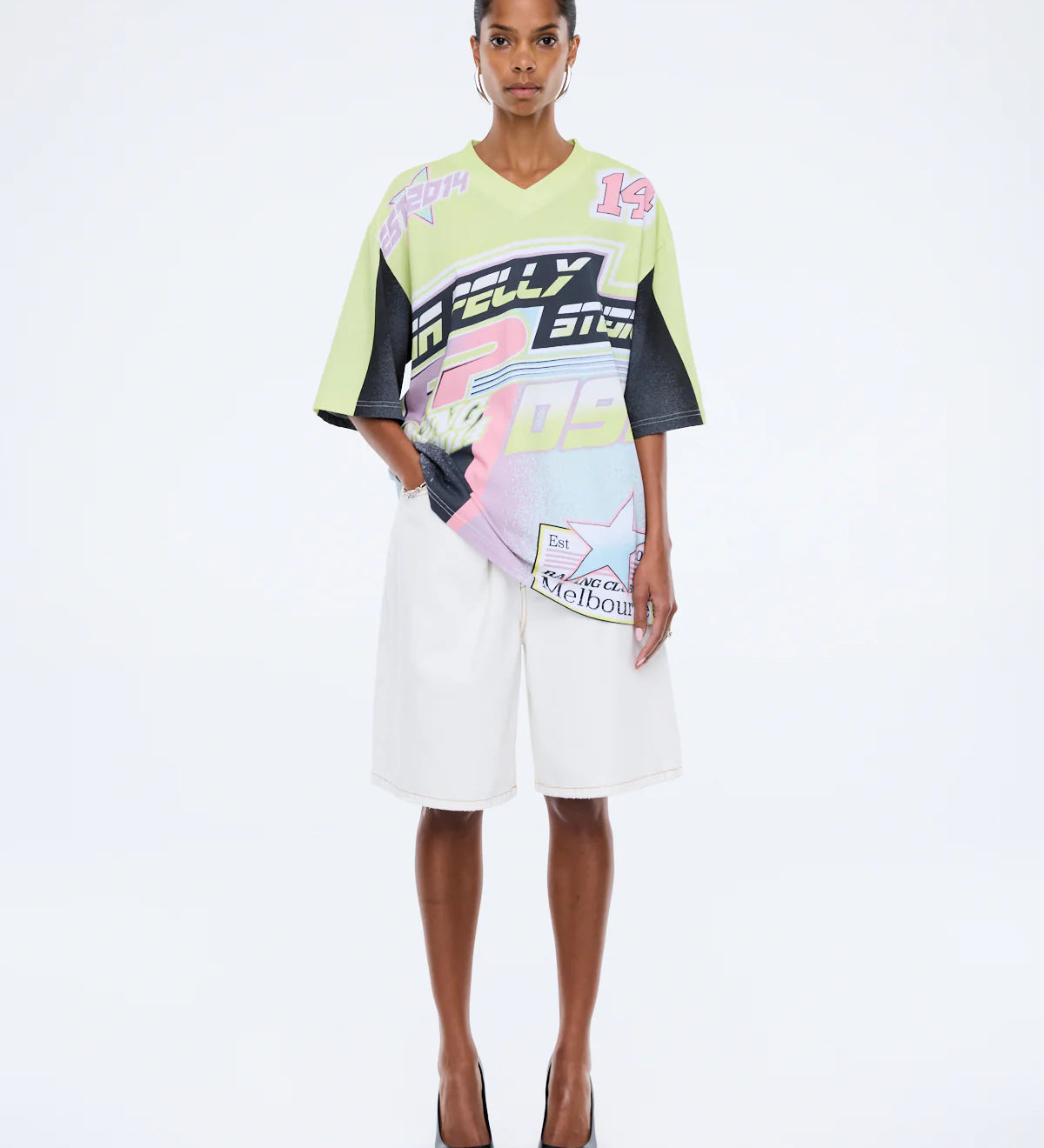 Model wearing a colorful outfit with brand logos on a white background