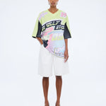 Model wearing a colorful outfit with brand logos on a white background