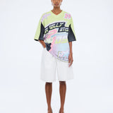 Model wearing a colorful outfit with brand logos on a white background