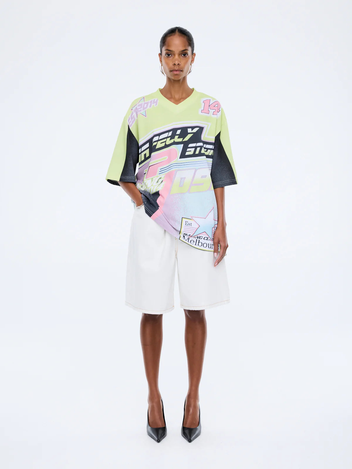 Model wearing a colorful outfit with brand logos on a white background