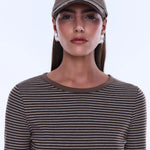 Woman wearing a brown cap and striped shirt against a white background