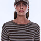 Woman wearing a brown cap and striped shirt against a white background