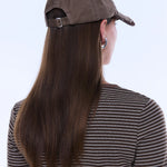 Person wearing a brown cap and striped shirt with long hair, on a white background