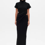 Woman wearing a black Top with a high neckline  and a long black skirt on a white background