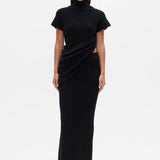 Woman wearing a black Top with a high neckline  and a long black skirt on a white background