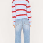 Person wearing a red and blue striped sweater and light blue jeans on a white background