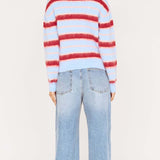 Person wearing a red and blue striped sweater and light blue jeans on a white background