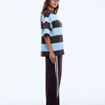 Person wearing a striped tee and cap on a white background