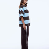 Person wearing a striped tee and cap on a white background