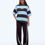 Person wearing a brown and blue striped shirt with a cap on a white background