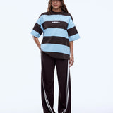 Person wearing a brown and blue striped shirt with a cap on a white background