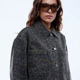 Woman wearing a patterned coat and sunglasses on a white background
