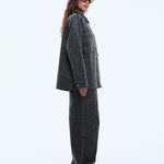 Woman wearing a gray coat and pants on a white background