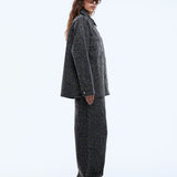 Woman wearing a gray coat and pants on a white background