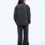Person wearing a gray patterned outfit on a white background