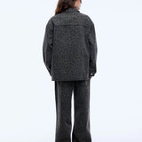 Person wearing a gray patterned outfit on a white background
