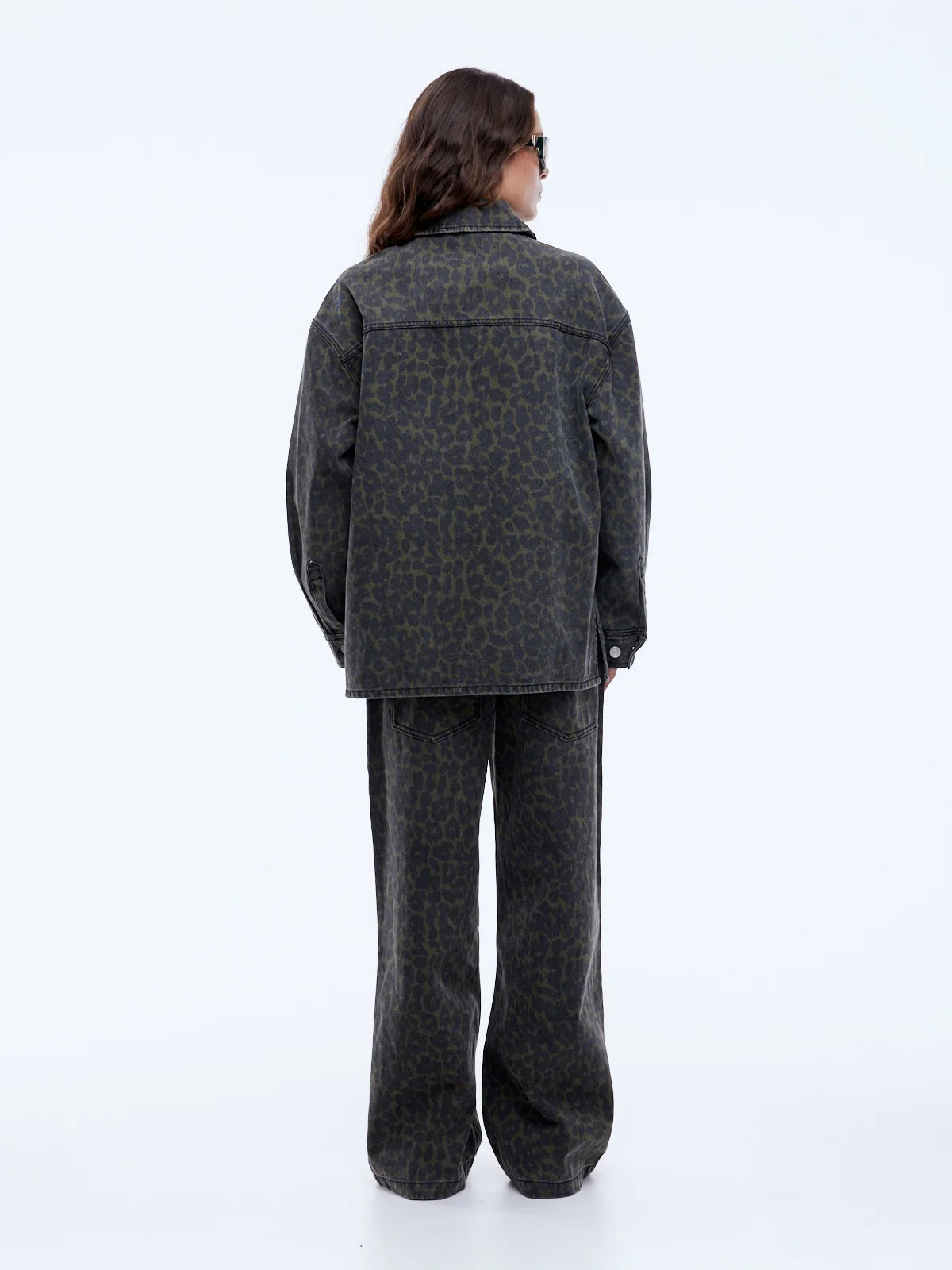 Person wearing a gray patterned outfit on a white background
