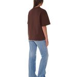 Person wearing a brown t-shirt and blue jeans on a white background