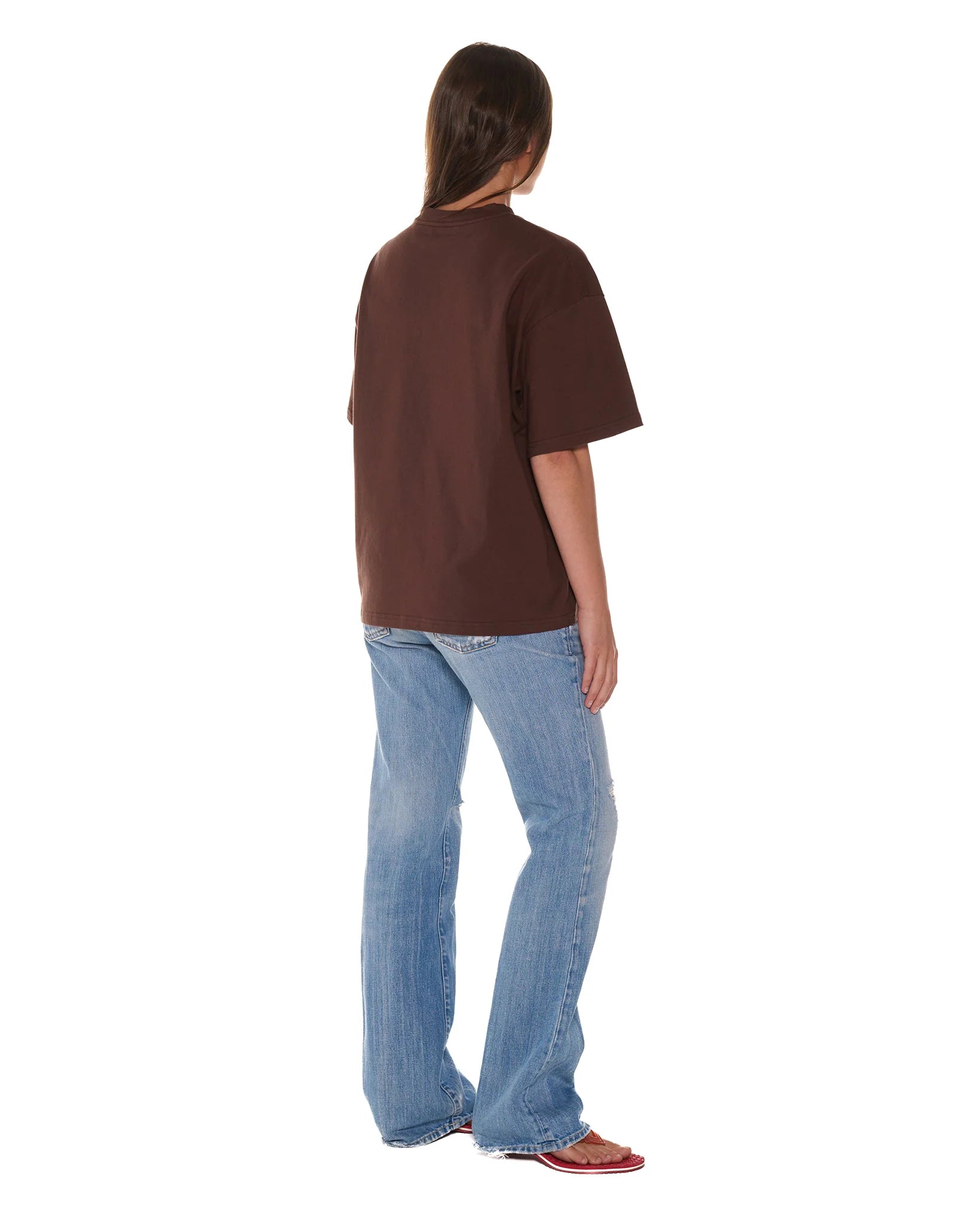 Person wearing a brown t-shirt and blue jeans on a white background