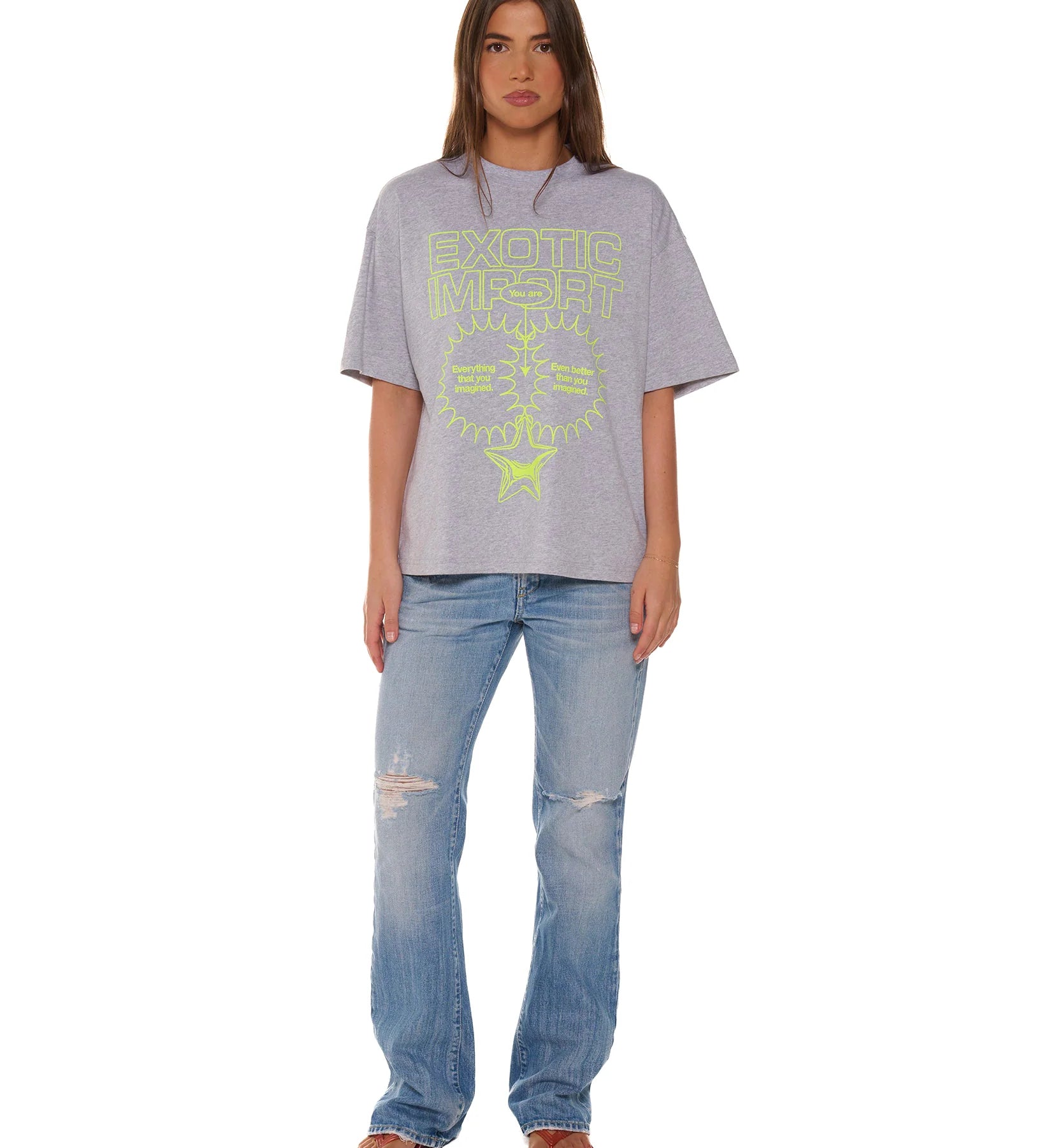 Person wearing a gray t-shirt with text and blue jeans on a white background