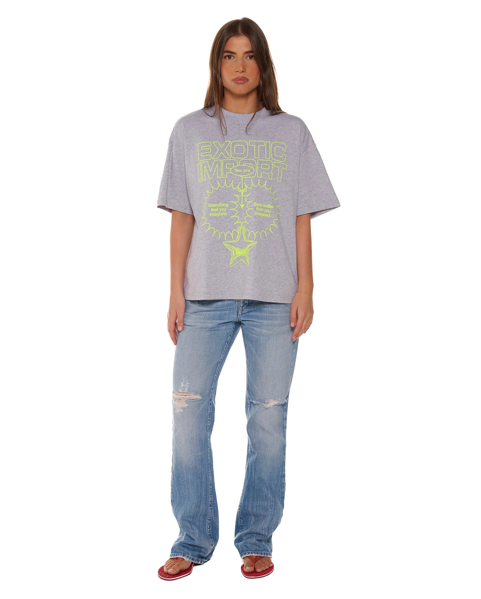 Person wearing a gray t-shirt with text and blue jeans on a white background
