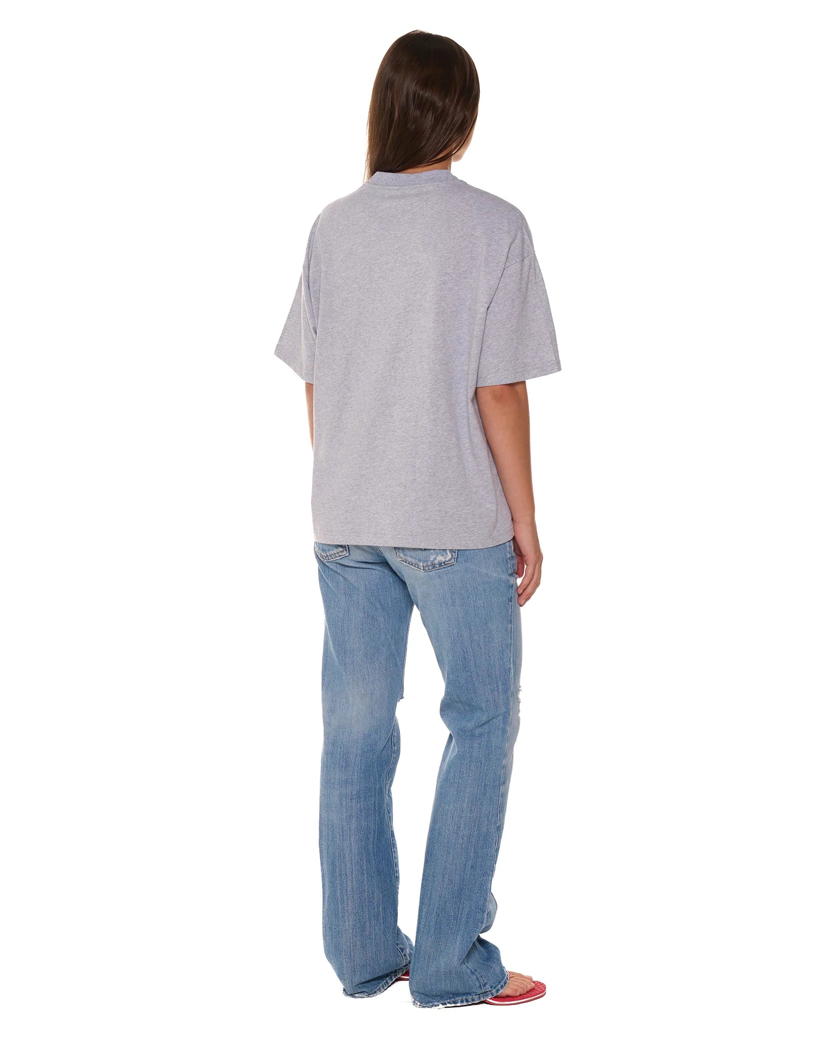 Person wearing a gray t-shirt and blue jeans on a white background