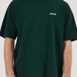 Person wearing a dark green t-shirt with a logo on a white background