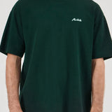 Person wearing a dark green t-shirt with a logo on a white background