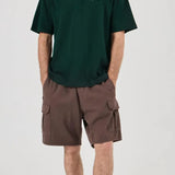 Person wearing a green t-shirt and brown cargo shorts on a white background