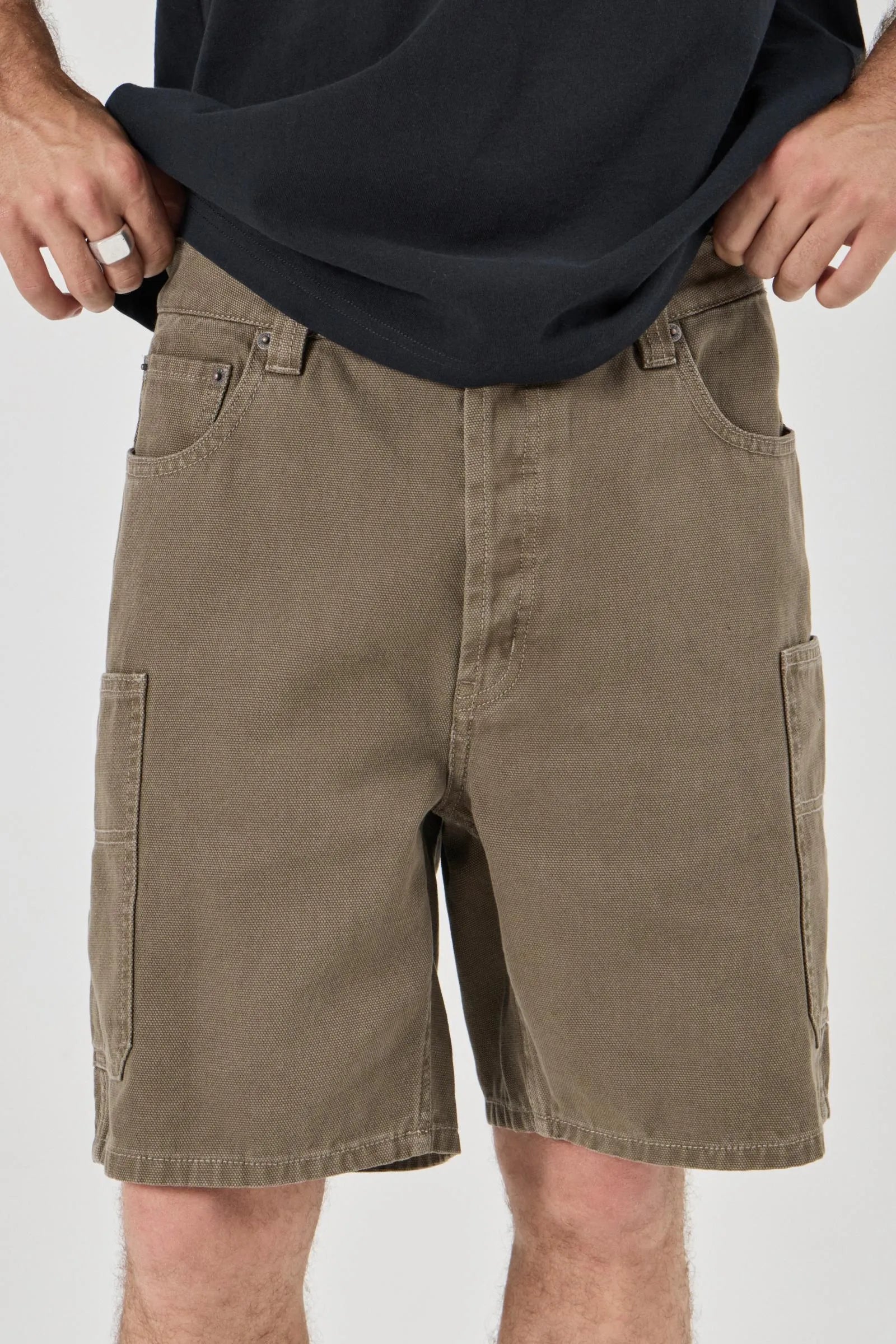 Olive cargo shorts worn by a person on a white background