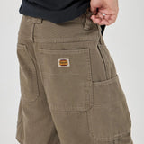 Person wearing Olive shorts with a visible brand logo on a white background