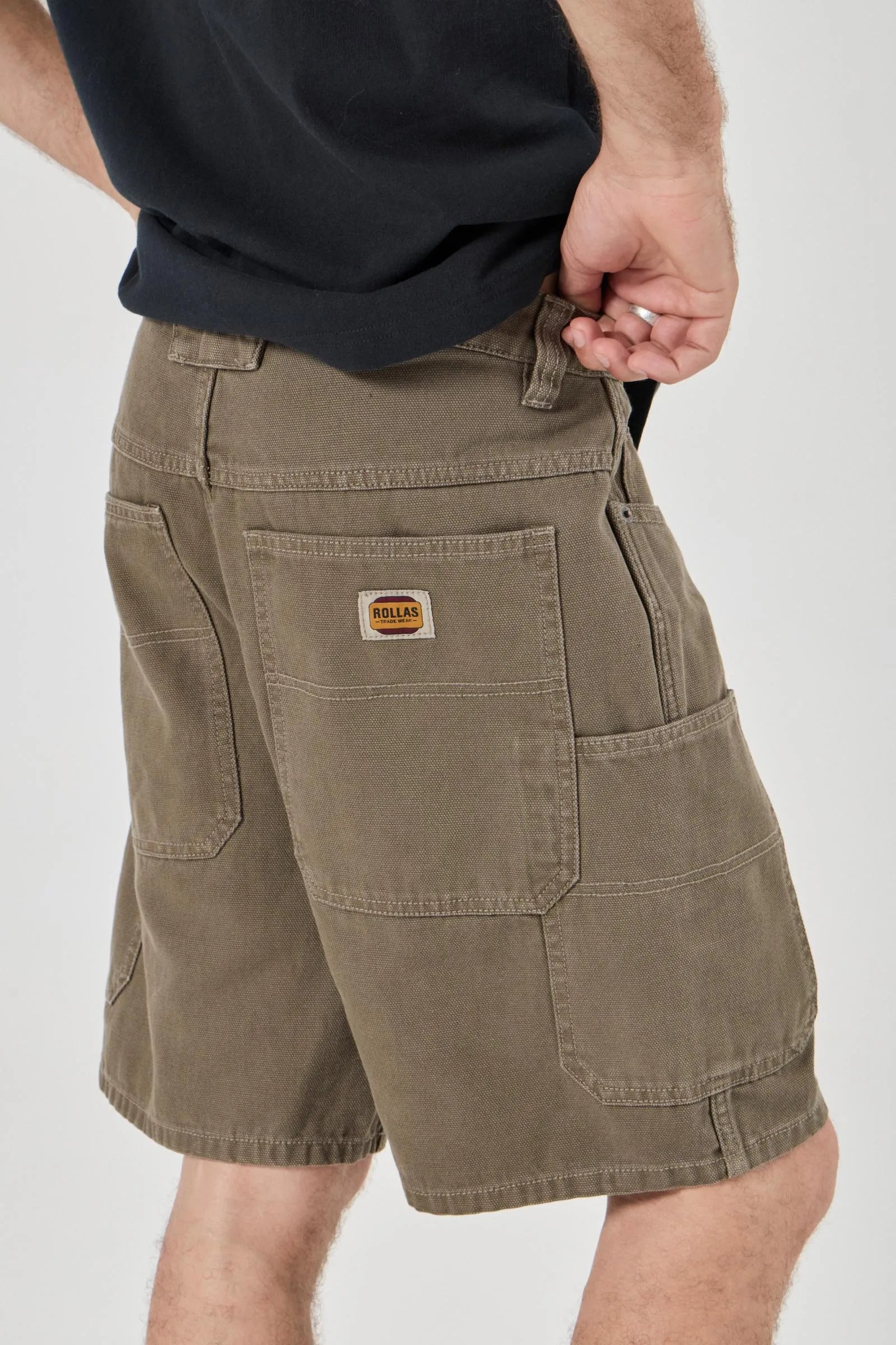 Person wearing Olive shorts with a visible brand logo on a white background