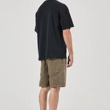 Man wearing a black t-shirt and olive shorts on a white background
