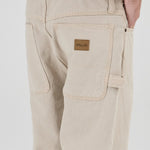 Beige pants with a brand label on a white background