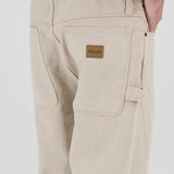 Beige pants with a brand label on a white background