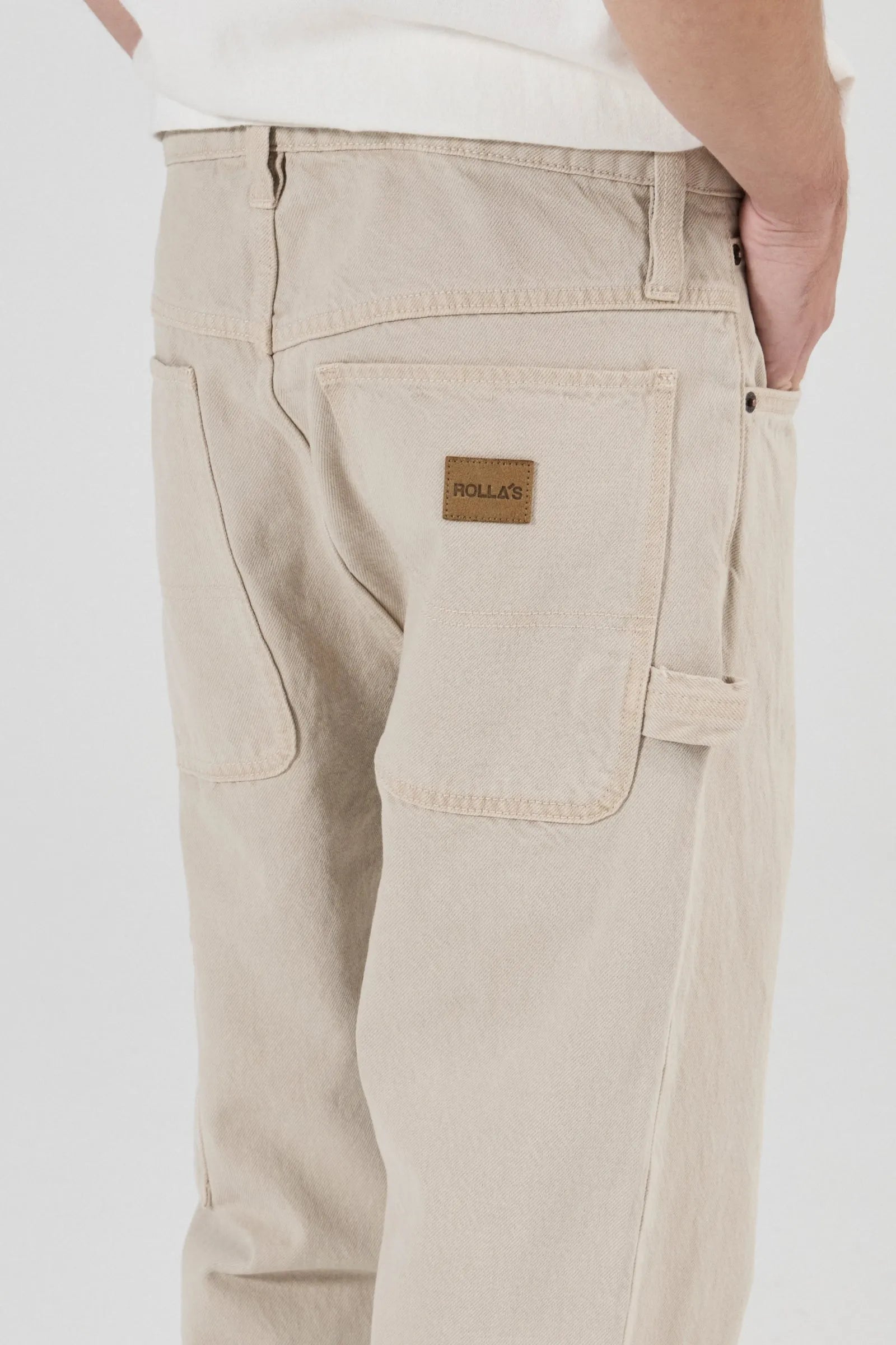 Beige pants with a brand label on a white background
