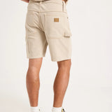 A person shown from the back wearing light beige cargo shorts, a matching beige top, white socks, and gray sneakers against a plain white studio background.
