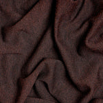 A close-up of draped dark brown fabric with a soft, textured weave and subtle sheen.