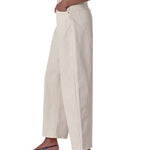 Person wearing beige wide-leg pants on a white background