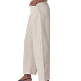 Person wearing beige wide-leg pants on a white background