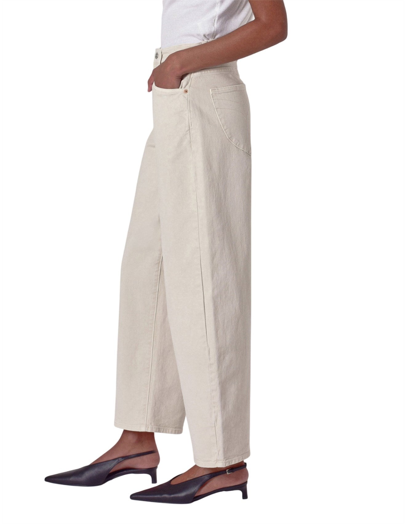 Person wearing beige wide-leg pants on a white background