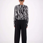 Person wearing a black and white striped shirt and black pants on a white background