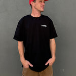 Man wearing a black t-shirt with 'TOKO' logo and a red cap on a gray background